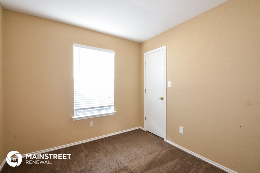 the interior of a bedroom with a door and a window