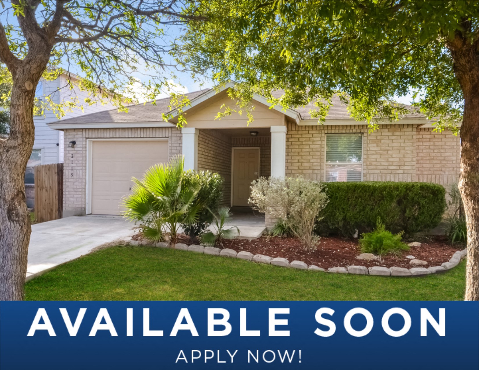 a small tan house with a yard and a tree