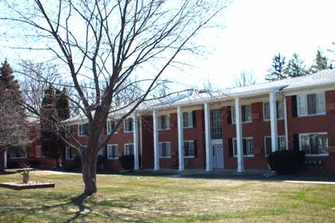 an apartment building with a tree in front of it