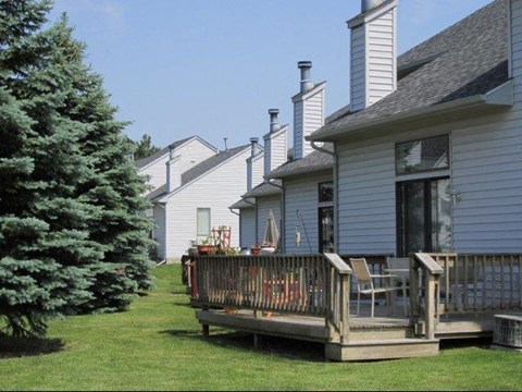 a house with a deck and a pine tree
