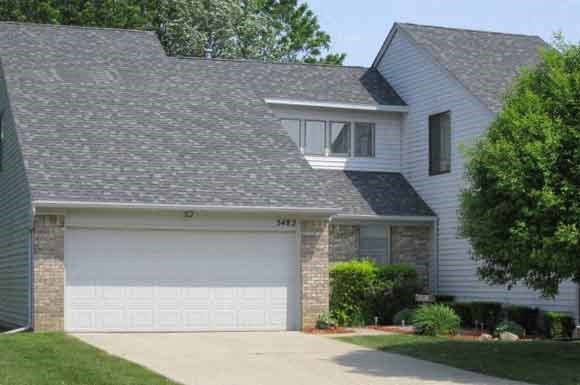 a house with a gray roof and a white garage door