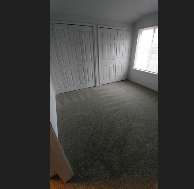 a room with a carpeted floor and a window