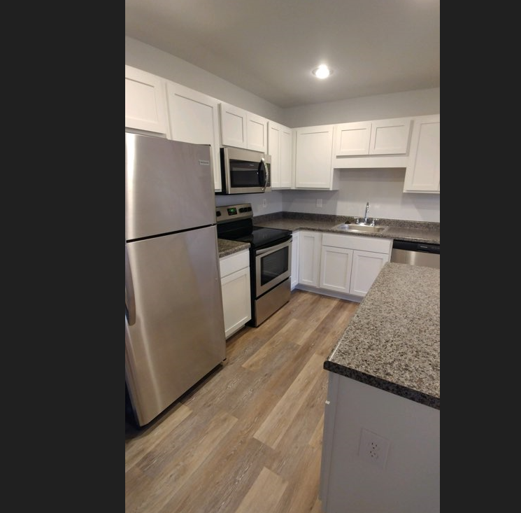 a kitchen with stainless steel appliances and white cabinets