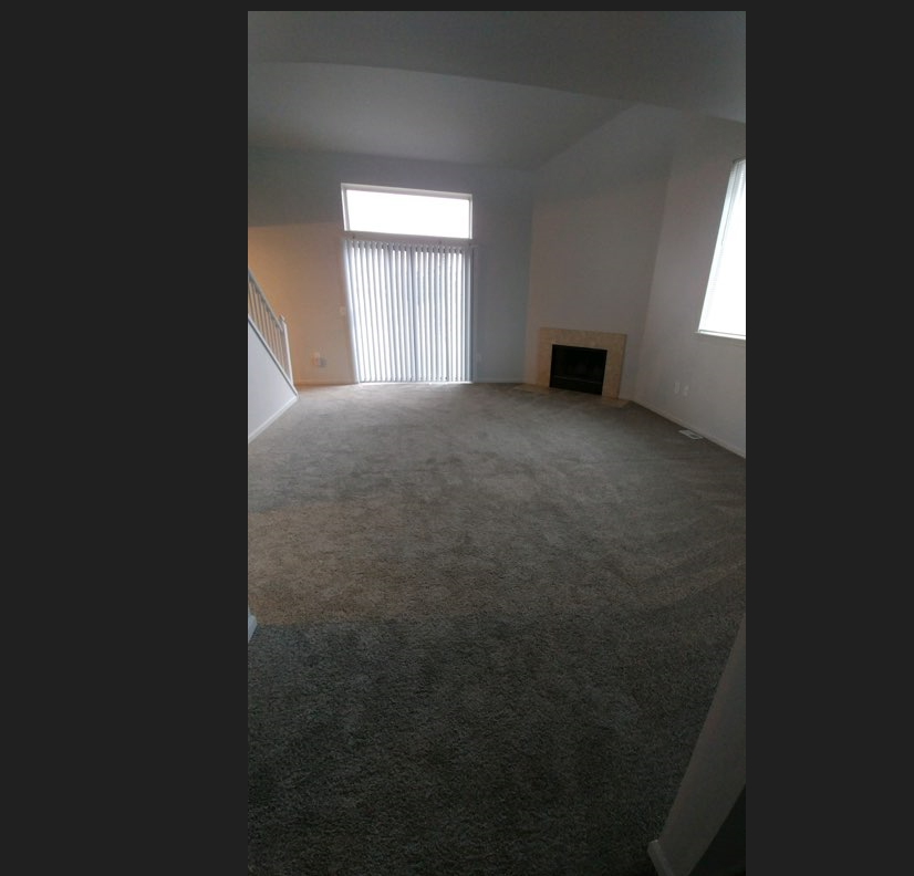 an empty living room with a fireplace and a window
