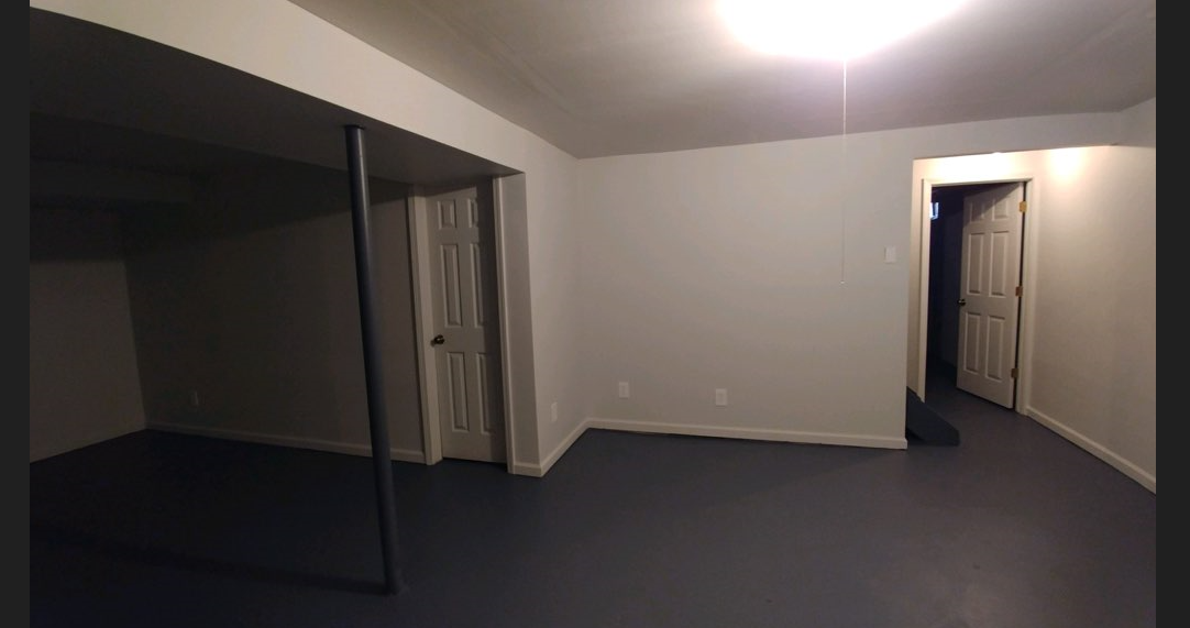 an empty living room with white walls and a door