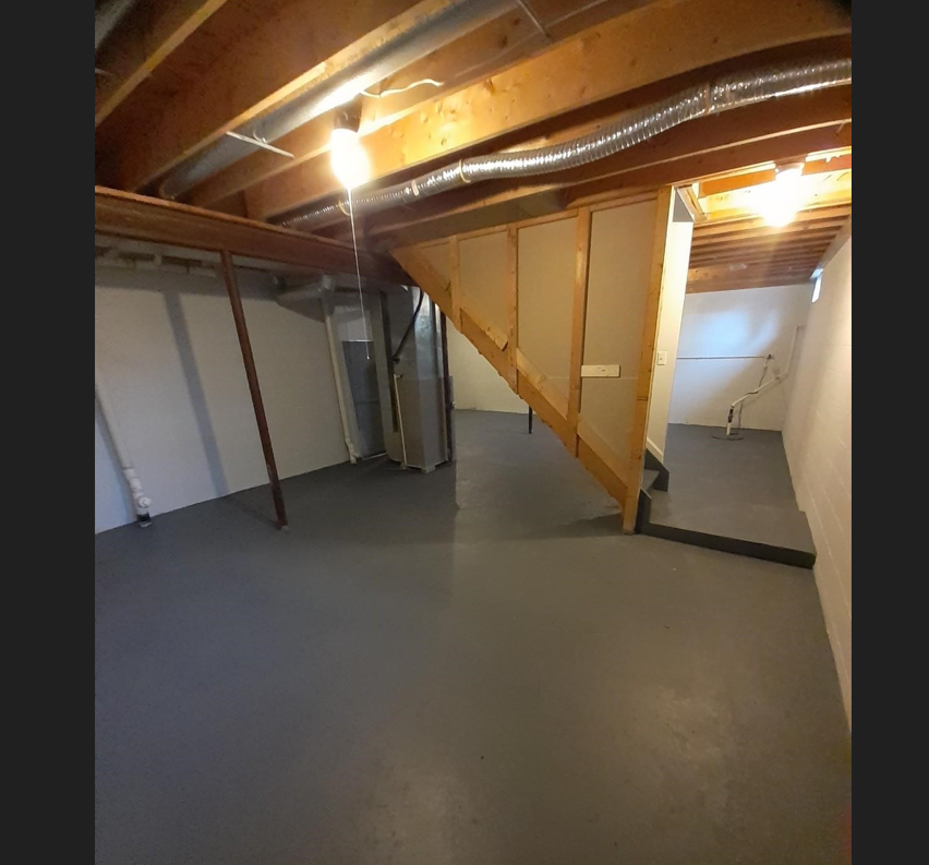 a basement with a concrete floor and a staircase