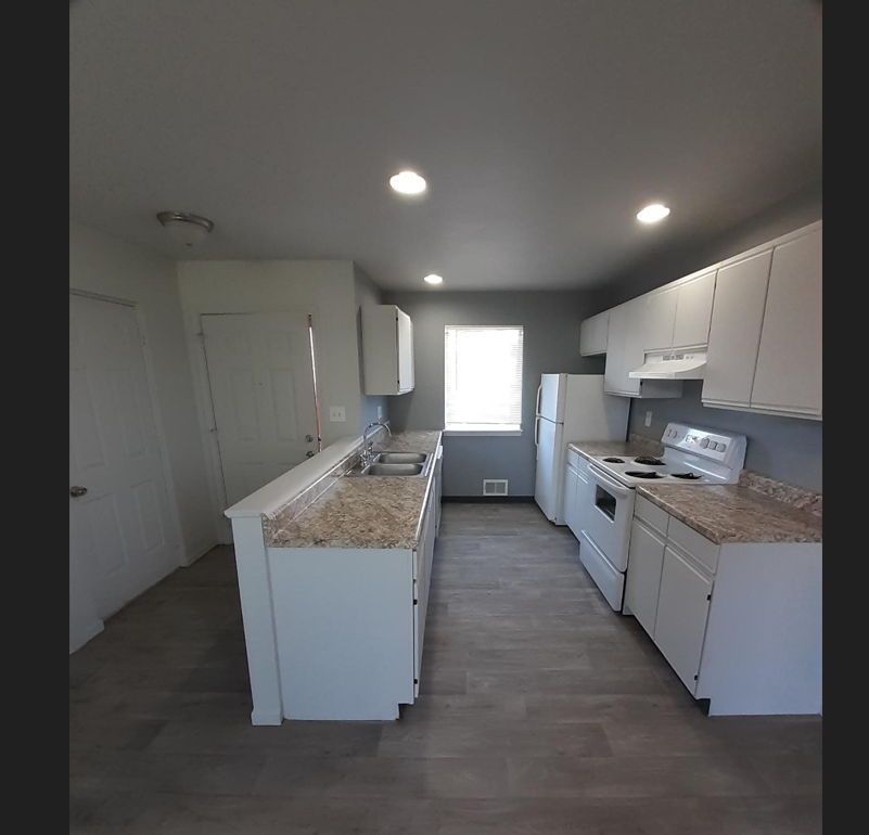 a kitchen with white cabinets and granite counter tops
