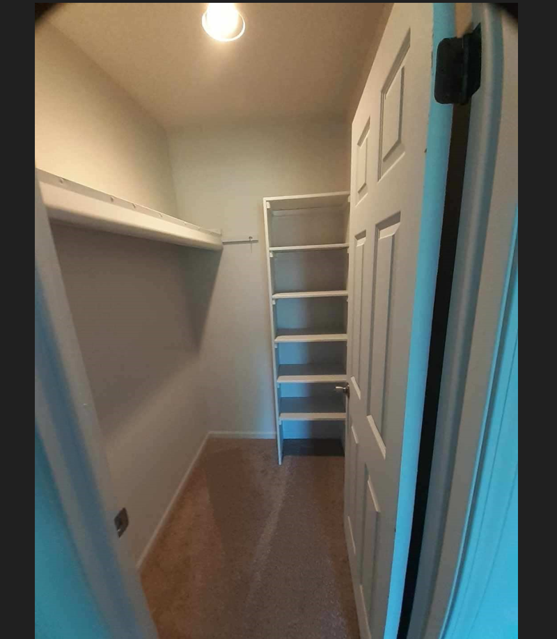 a small closet with a ladder and a white door