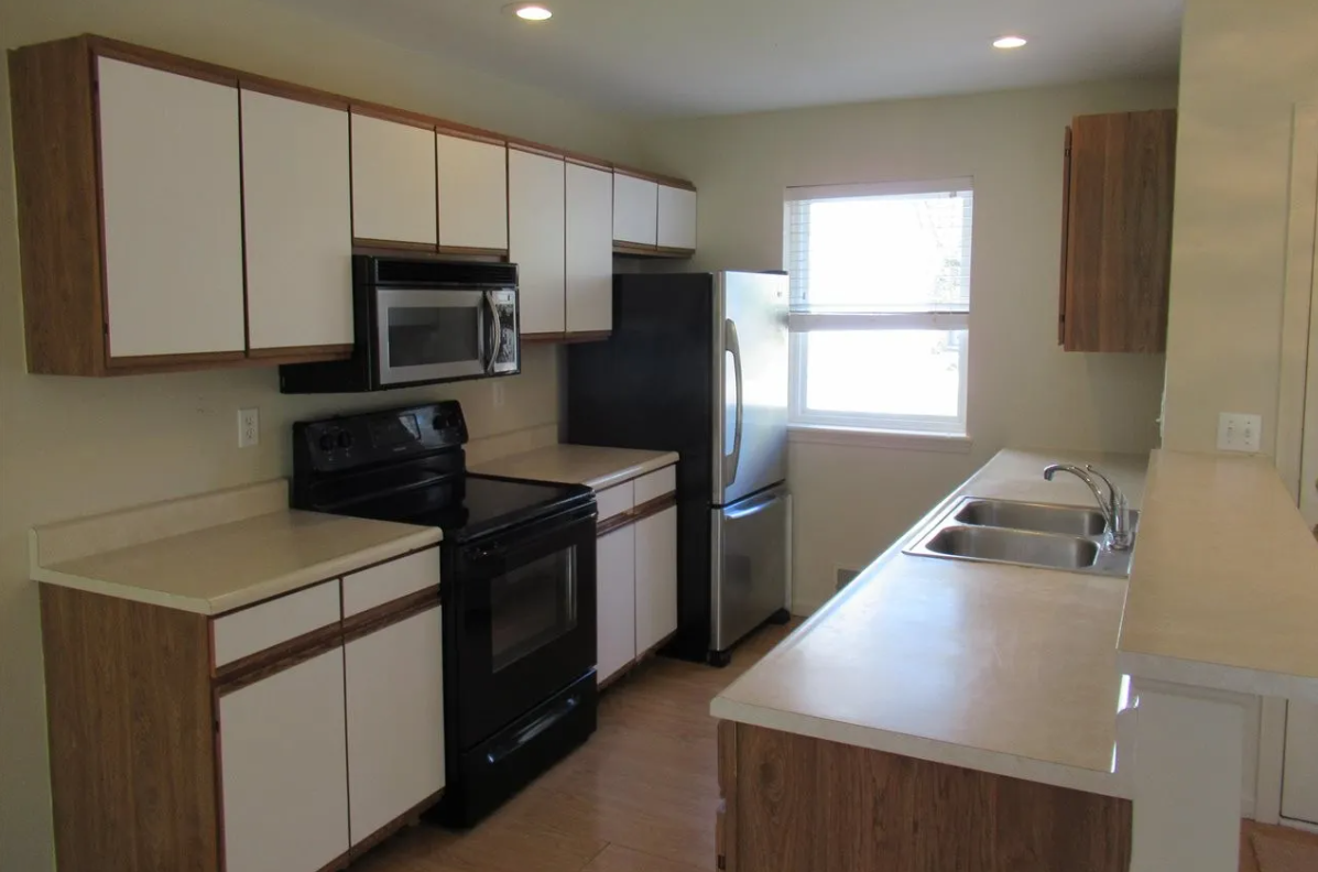 a kitchen with black appliances and white cabinets