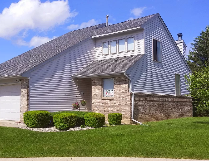 a blue house with a lawn in front of it