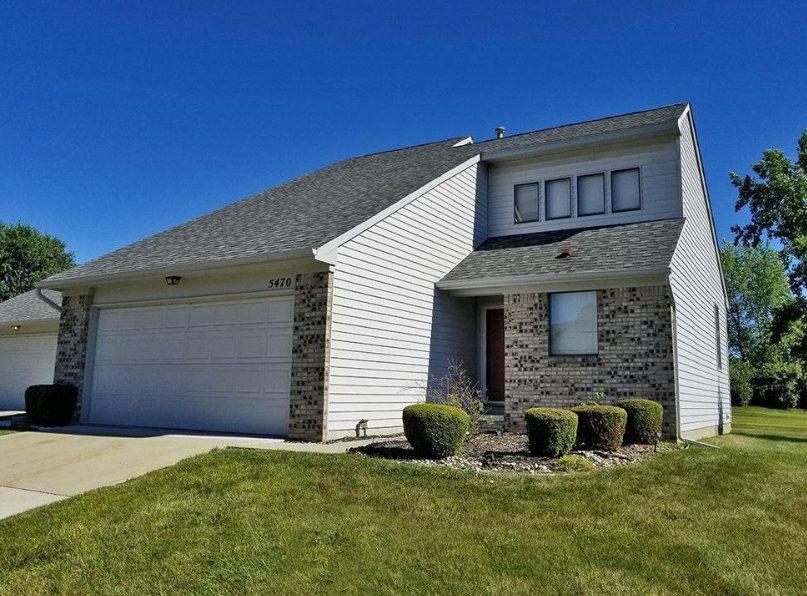 a white house with a garage and a lawn