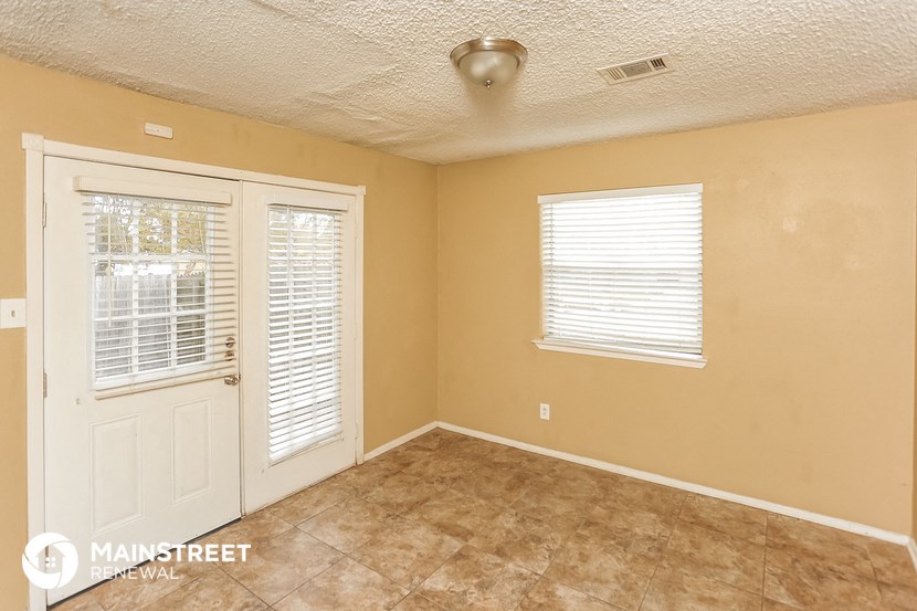 the living room of an empty house with a door and window
