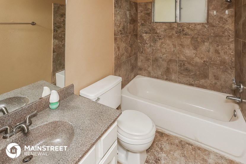 a bathroom with a toilet and a tub and a sink