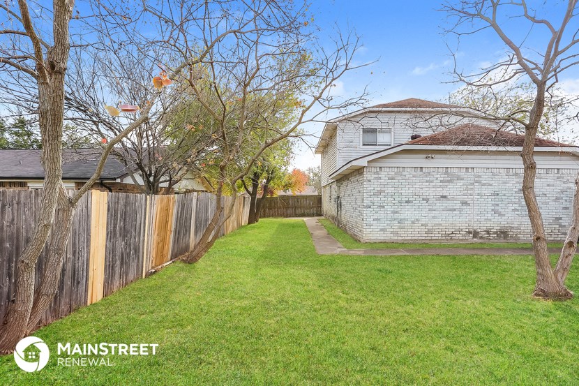 the backyard of a house with a yard and a fence