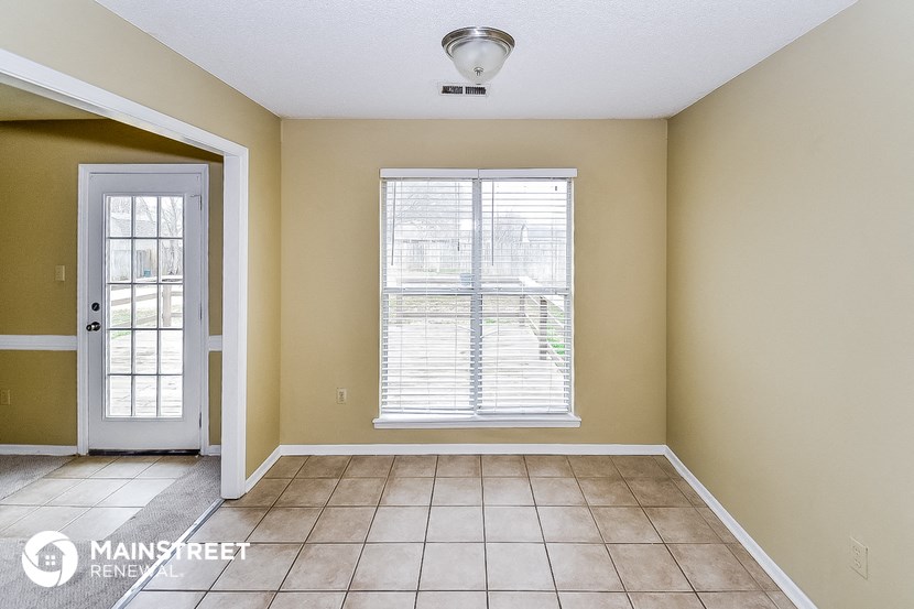 a living room with a large window and a tiled floor