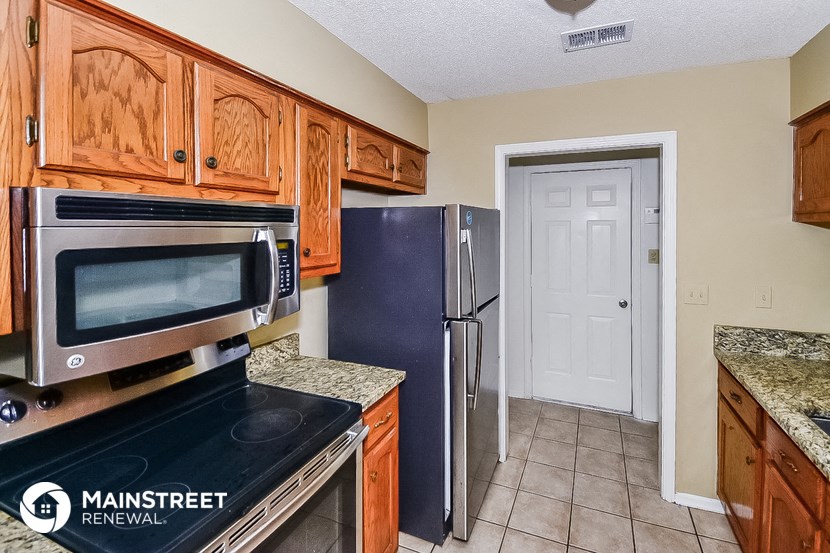 a kitchen with wood cabinets and black appliances and a refrigerator
