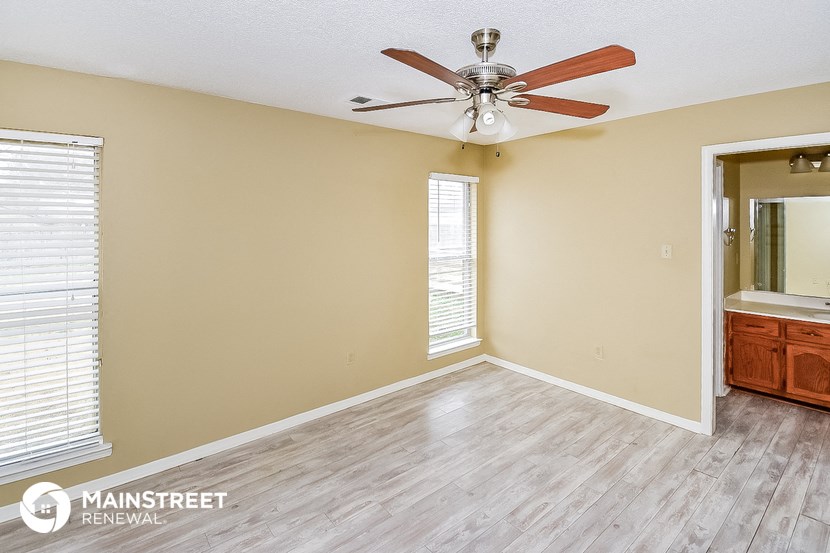 a living room with a ceiling fan and a mirror