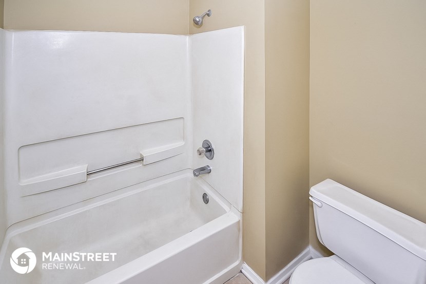 a bathroom with a toilet and a tub and a sink