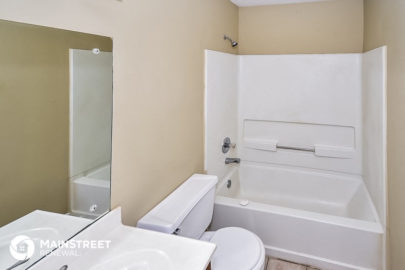 a bathroom with a tub and a toilet and a sink