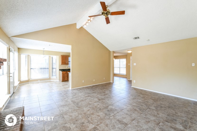 an empty living room with a ceiling fan