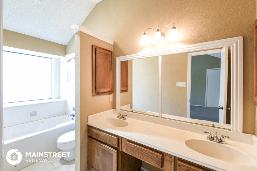 a bathroom with a sink and a mirror and a toilet and a tub