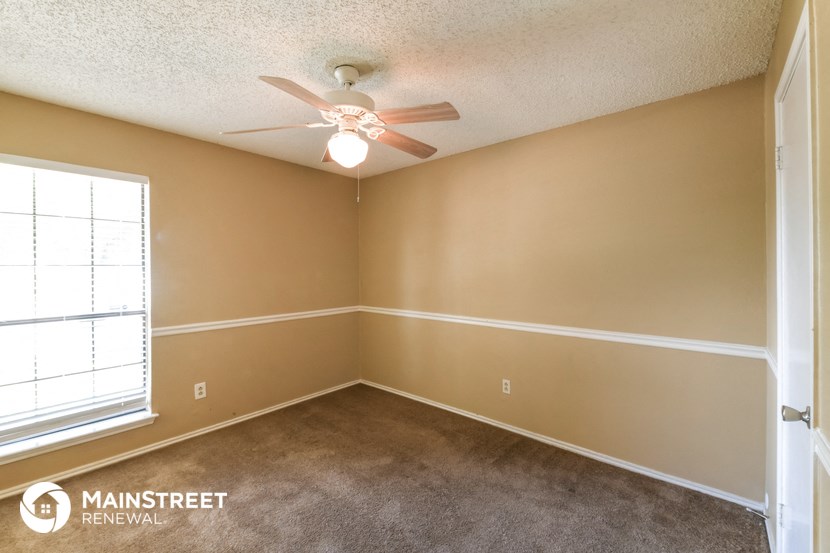 a bedroom with a ceiling fan and a window
