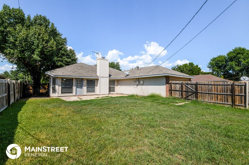 a backyard with a fence and a house