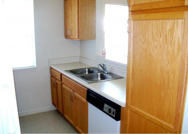 a small kitchen with a sink and a refrigerator