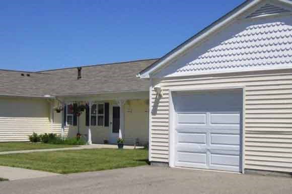 a white house with a white garage door and a lawn