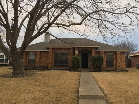 a brick house with a tree in front of it