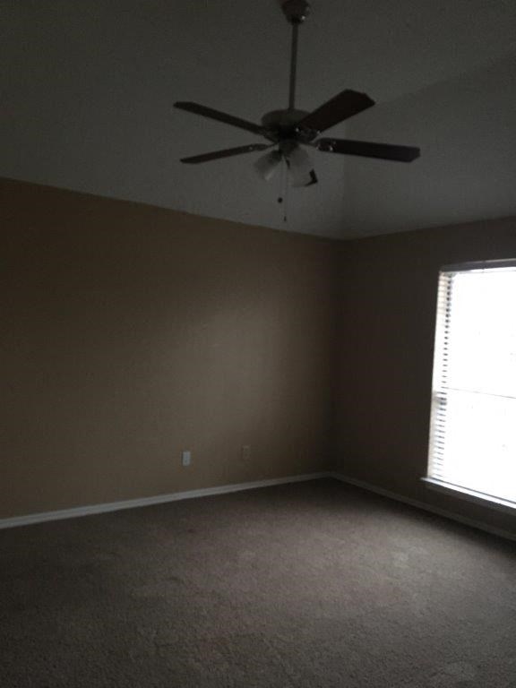 a living room with a ceiling fan and a window