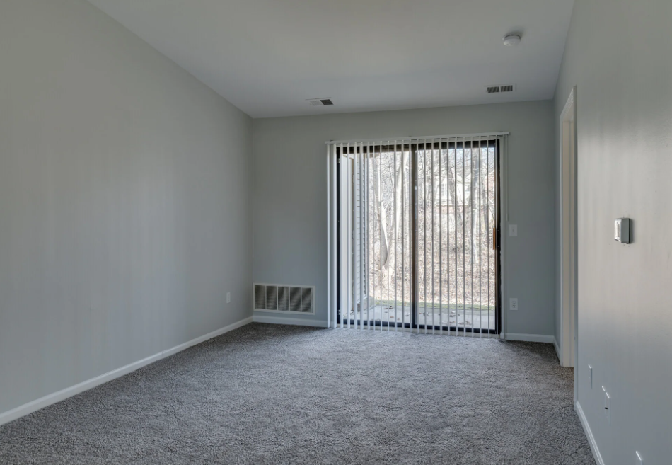 a living room with a large window and a door to a balcony