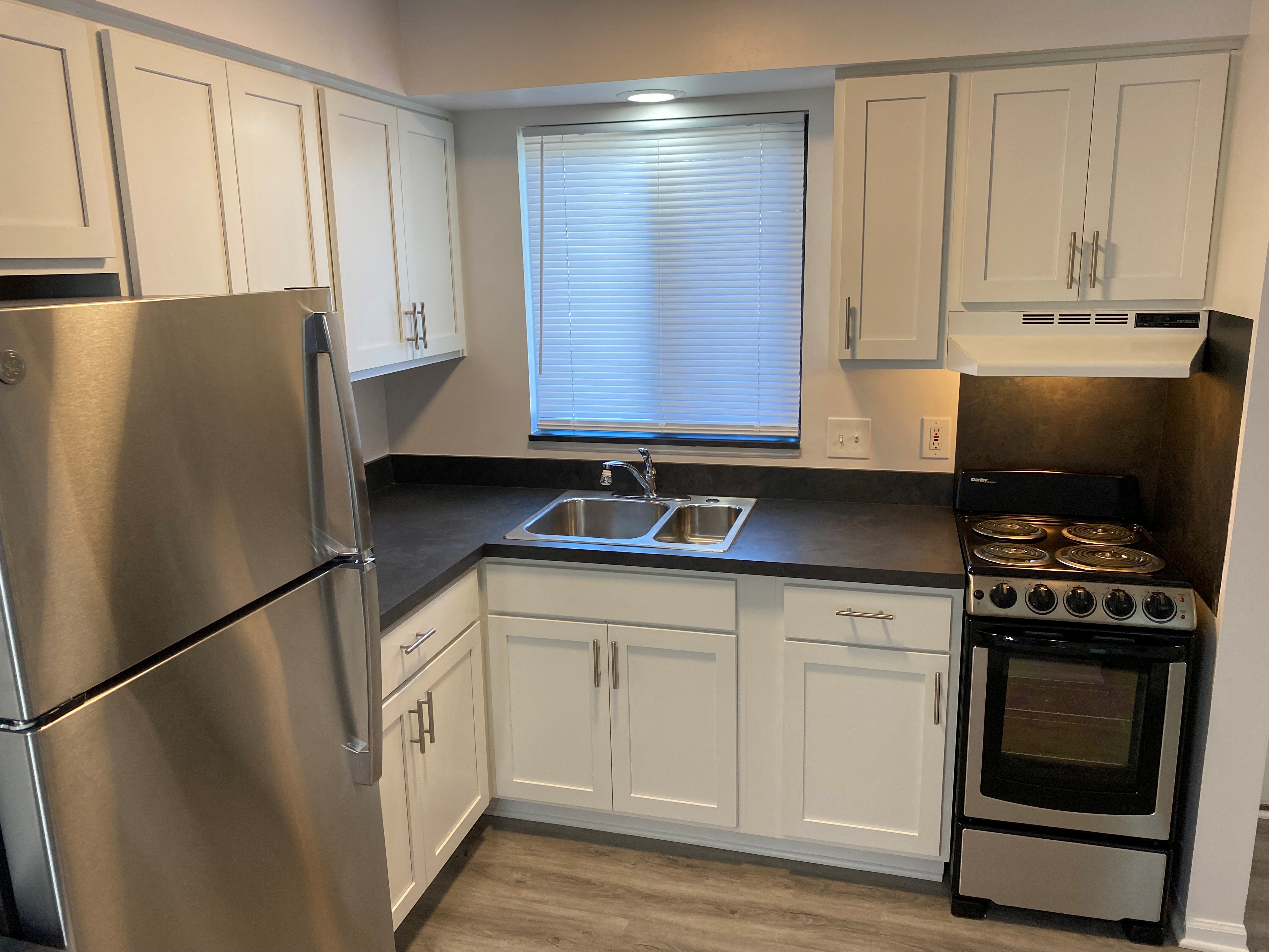 a kitchen with white cabinets and stainless steel appliances