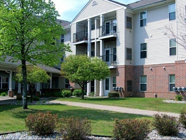 an apartment building with a sidewalk in front of it