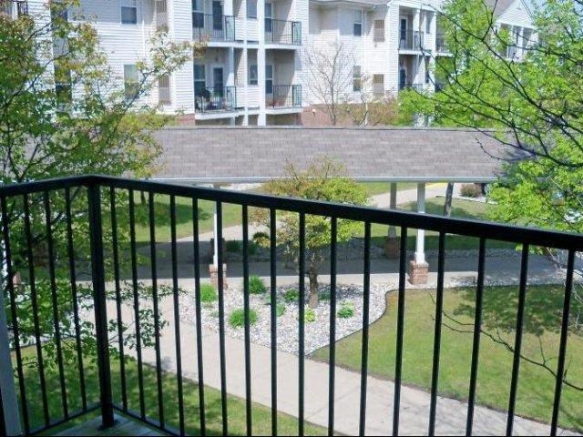 a balcony with a view of a river and a house