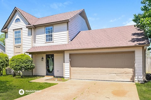 a white house with a driveway and a garage door