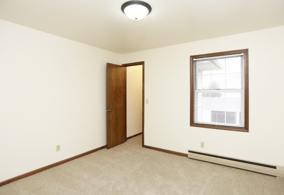 a bedroom with a window and a door to a closet
