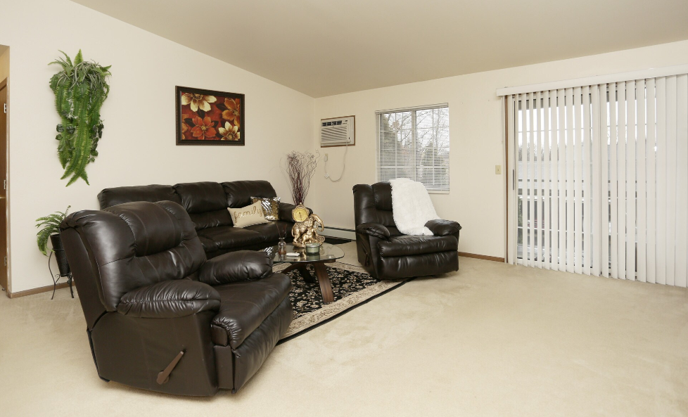 a living room with leather furniture and a sliding glass door