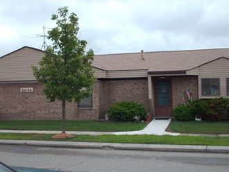 a brick house with a tree in front of it