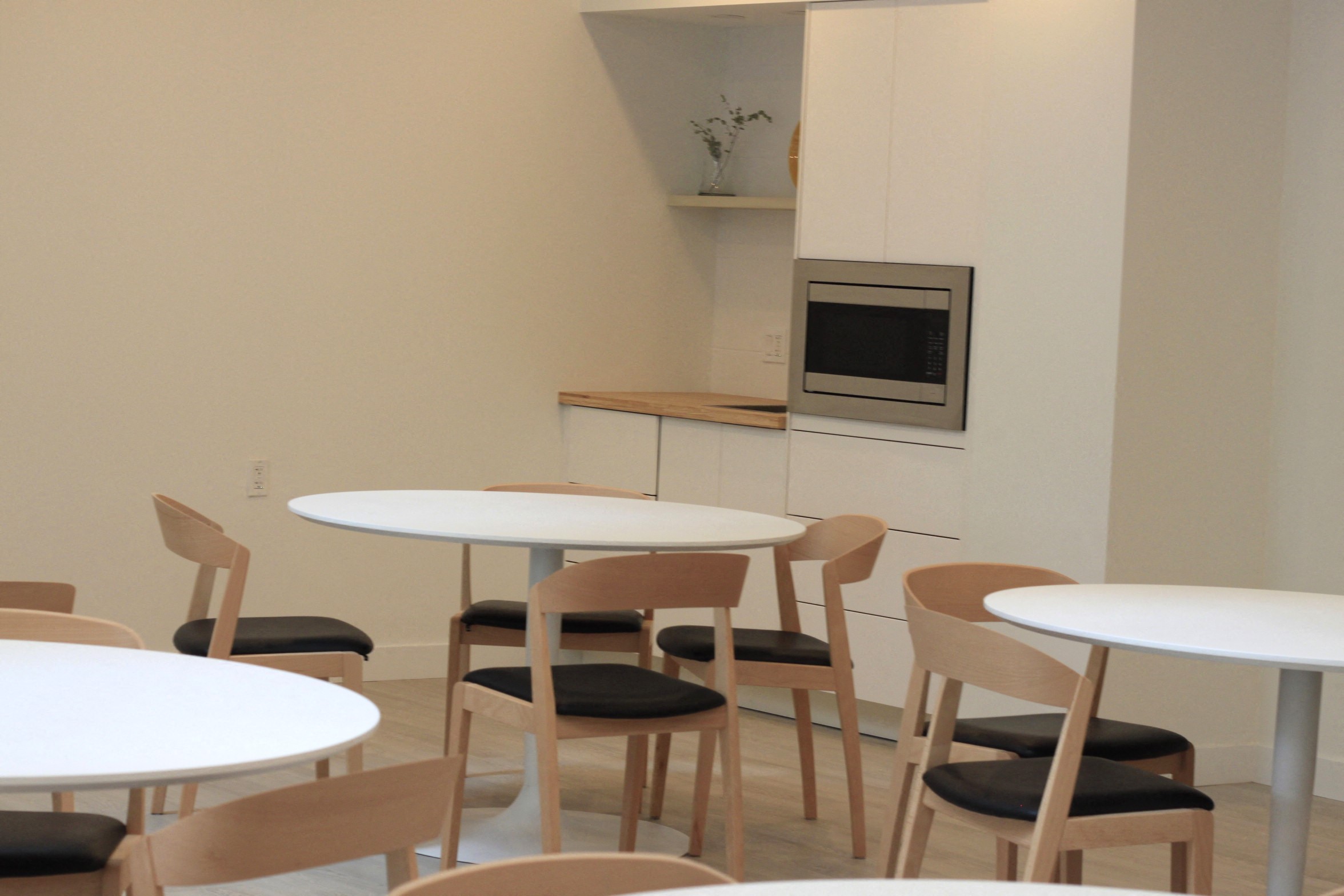 a dining room with tables and chairs and a microwave
