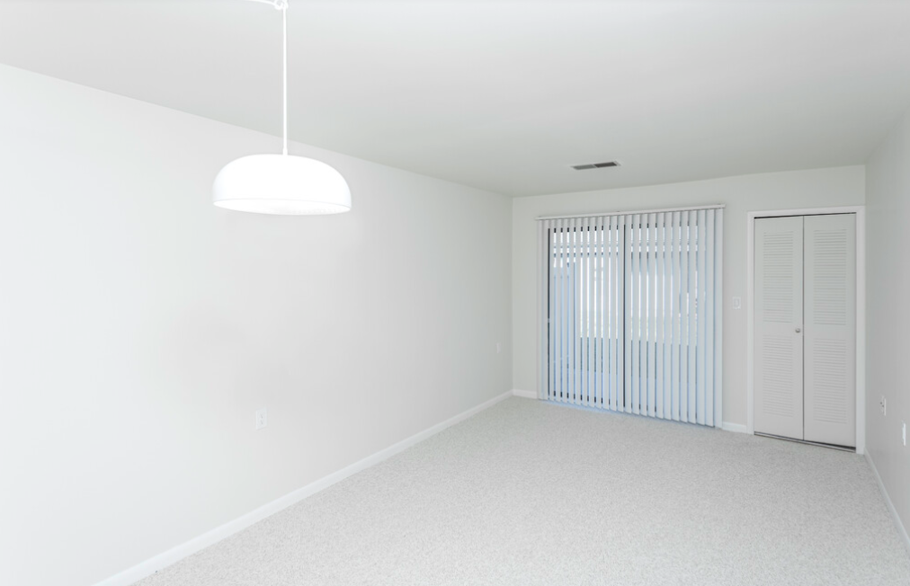 an empty living room with white walls and a white door