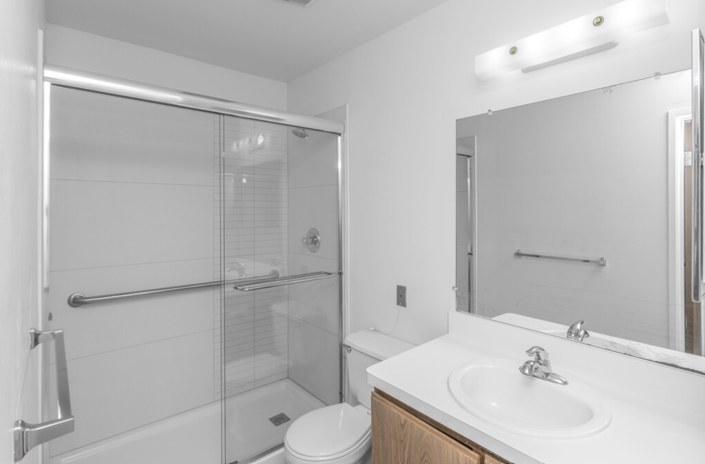 a bathroom with a shower and a sink and a toilet