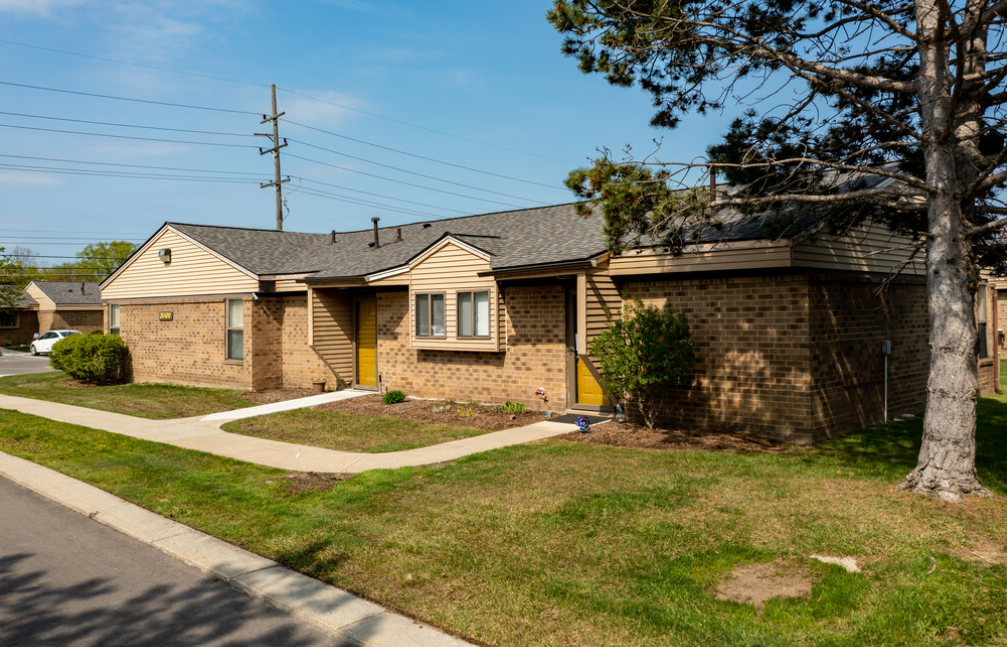 a brick house with a sidewalk in front of it