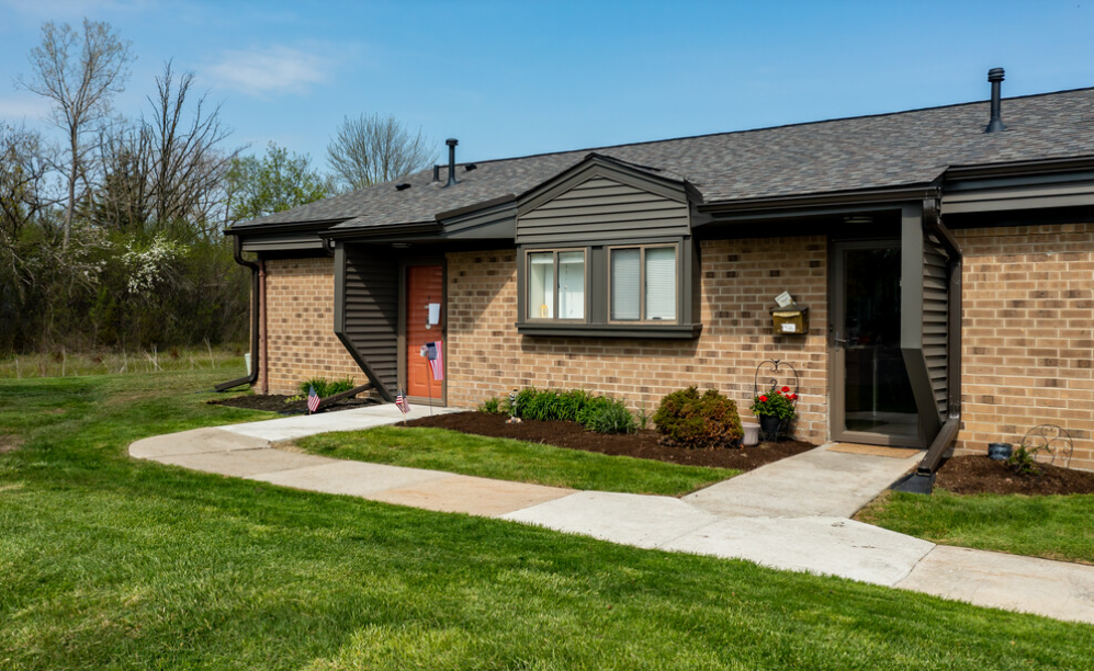 a brick house with a sidewalk in front of it