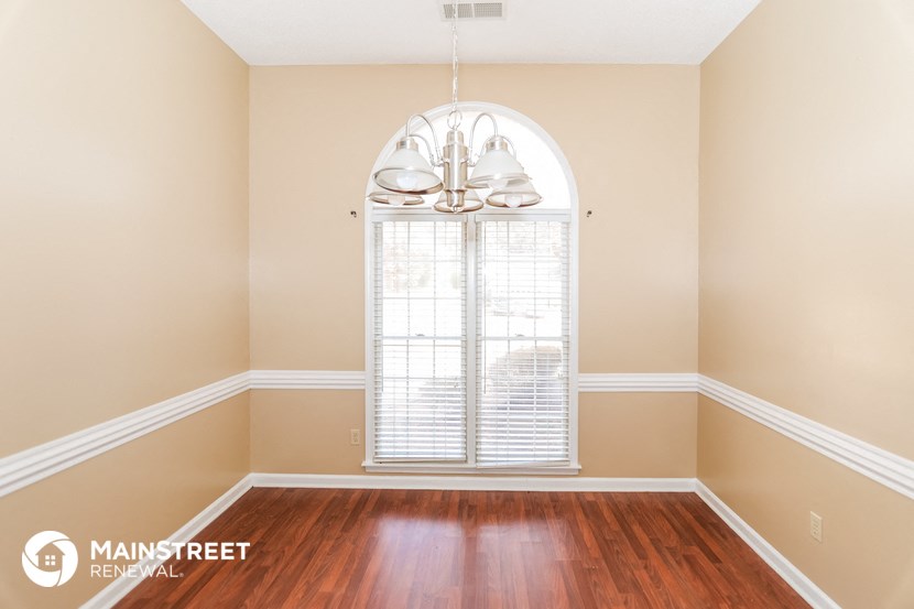 the living room after renovation with wood floors and a large window