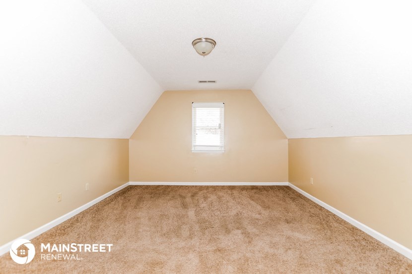 the bedroom with carpeted floors and a window