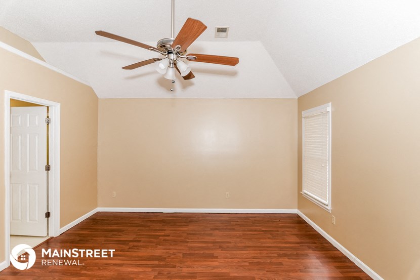 the master bedroom has a ceiling fan and hardwood floors