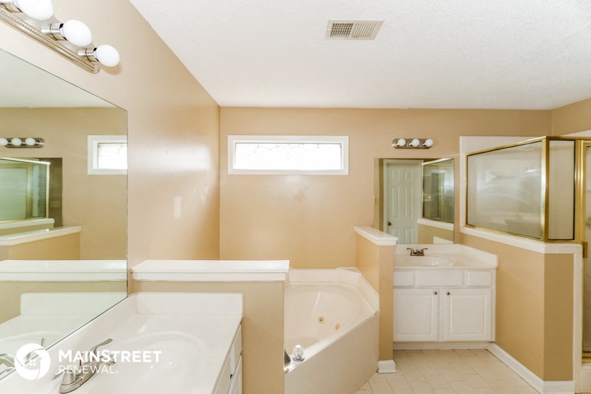 a bathroom with a tub and a sink and a mirror