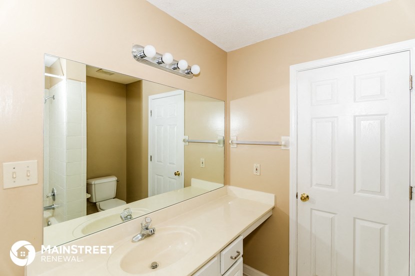 a bathroom with a large mirror and a white sink