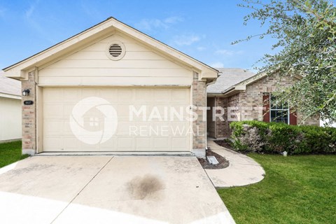 a garage with a driveway and a brick house